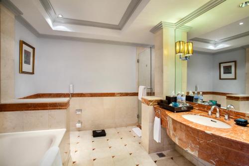 a bathroom with a large sink and a tub at Wyndham Casablanca Jakarta in Jakarta