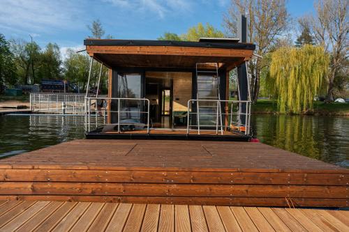 a small house on a dock on a body of water at House Boat s výhledem na Wake Port in Brandýs nad Labem-Stará Boleslav