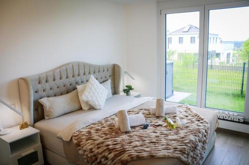 a bedroom with a large bed with a large window at Mountainview - Deluxe in Lottstetten