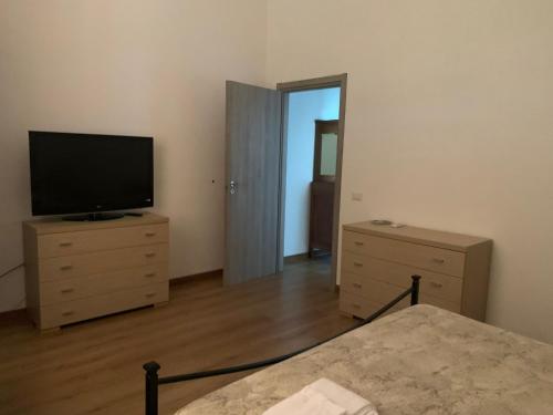 a bedroom with a television and a dresser with a bed at La Maremmana in Talamone