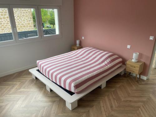 une chambre avec un lit avec une couverture rayée dans l'établissement Appartement Magnolia, à Brive-la-Gaillarde