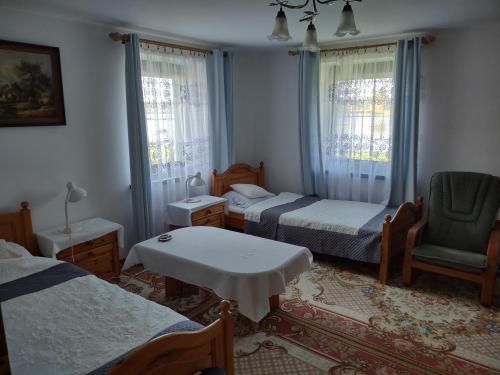 a bedroom with two beds and a table and a chair at Agroturystyka Nad Stawami in Krasowice