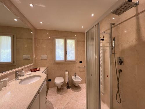 a bathroom with a shower and a toilet and a sink at Penthouse Valentino in Intra