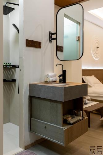 a bathroom with a sink and a mirror at 汕头寂居 Shantou Ancient City Design Hotel in Shantou