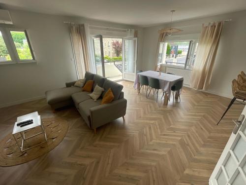 un salon avec un canapé et une table dans l'établissement Appartement Magnolia, à Brive-la-Gaillarde