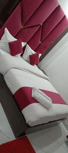 a bed with red and white sheets and pillows at HOTEL PEEPAL#TREE Near Rambag Railway Station -Free Parking And Wi-fi Facilities - A Top Rated Hotel in Prayagraj