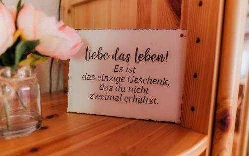 a sign on a table with flowers on it at Ferienhaus Nachtigall in Schorfheide