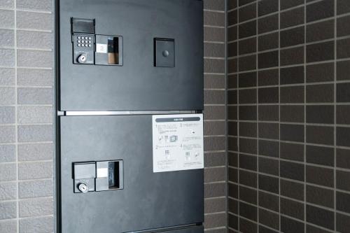a stainless steel refrigerator in a bathroom with tiles at Abe101 in Sapporo