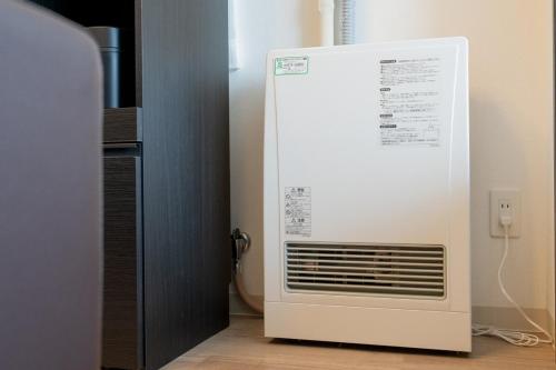 a white air conditioner sitting next to a wall at Abe101 in Sapporo