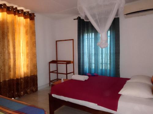 a bedroom with a bed and a window with curtains at Sky Villa Sigiriya in Sigiriya