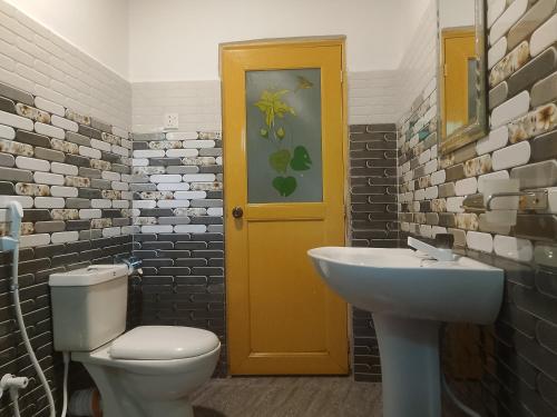 a bathroom with a toilet and a sink and a door at Sky Villa Sigiriya in Sigiriya