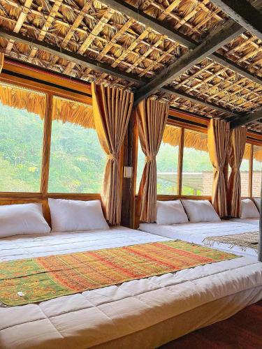 a bedroom with two large beds with windows at Ngũ Chỉ Sơn Trekking Sapa Homestay Local Experience in Sapa