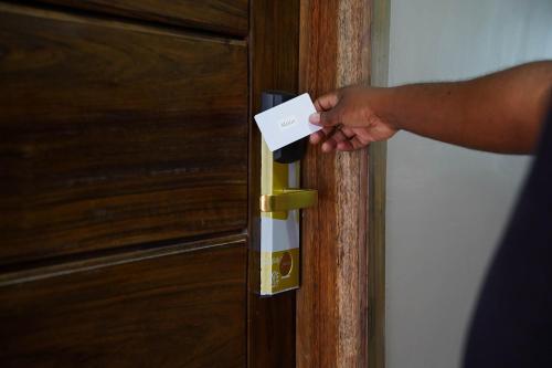 a person holding a piece of paper in front of a door at The Hideaway in Accra