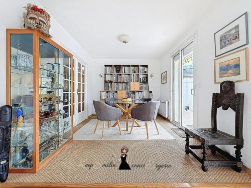 a living room with a table and a chair at L Oasis tout confort en Béarn in Gelos