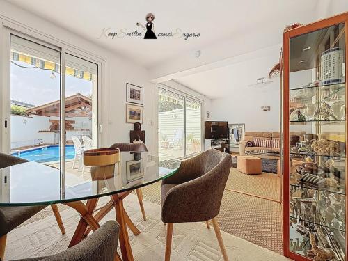 a dining room with a glass table and chairs at L Oasis tout confort en Béarn in Gelos