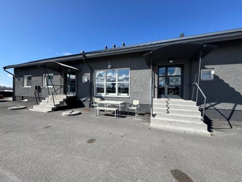 een gebouw met witte treden en een gebouw met ramen bij Kotimaailma - Vihtyisä Hostelli in Kokkola