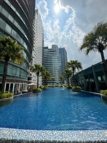 a large swimming pool in a city with tall buildings at Vortex Suites Klcc 2bedroom & 3bedroom apartment in Kuala Lumpur
