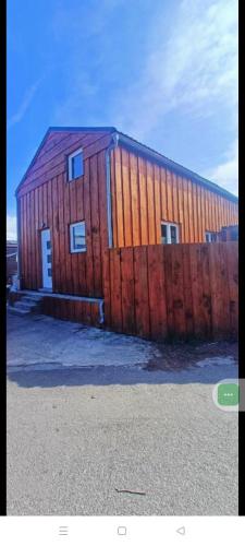 a wooden barn with a fence next to it at Chalet 5 personnes avec piscine in Yvoir