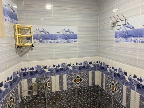 Un baño con un lavabo de mosaico con pájaros en la pared. en Nasrulla Samarqand Hotel, en Samarkand