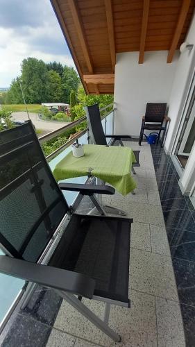 a patio with a table and chairs on a balcony at Ferienwohnung Maria Waldblick 95 qm, in Burtenbach