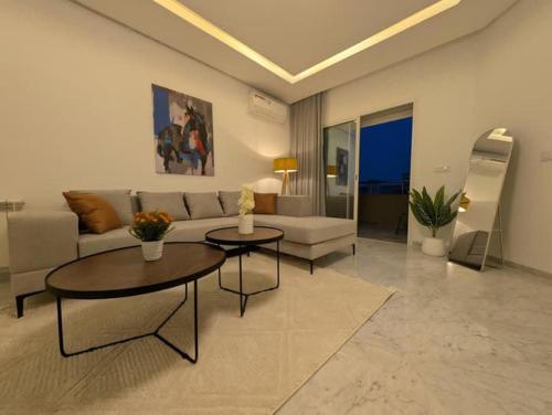 a living room with a couch and two tables at Dar GAMRA Luxury apartment with sea view in Hammamet Sud