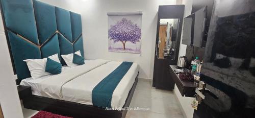 a bedroom with a large bed with a blue headboard at HOTEL PEEPAL#TREE Near Rambag Railway Station -Free Parking And Wi-fi Facilities - A Top Rated Hotel in Prayagraj