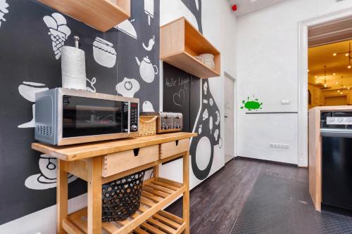 a kitchen with a microwave on a wooden table at Adagio Hostel Basilica in Budapest