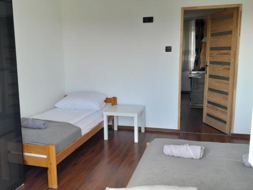 a bedroom with a bed and a table and a door at Apartament w Pieninach in Sromowce Wyżne