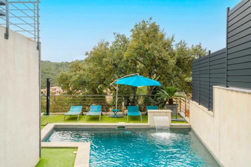 - une piscine avec des chaises bleues et un parasol dans l'établissement Magnifique Villa avec piscine en bord de mer, au Pradet