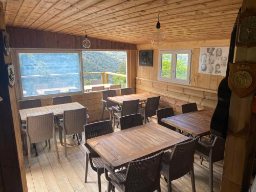 a restaurant with wooden tables and chairs and windows at Casa Versini in Balogna