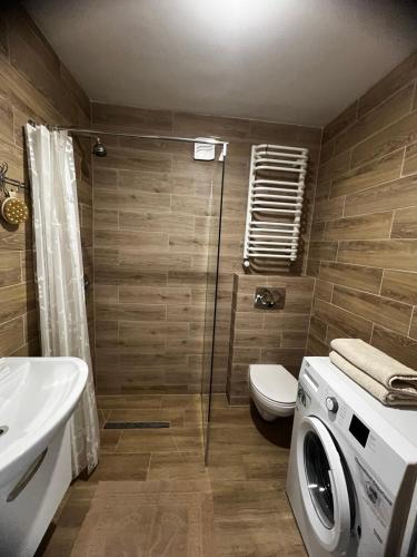 a bathroom with a shower and a washing machine at Valova 59 Apart in Kolomyya