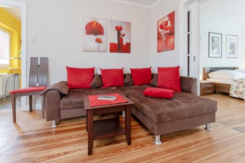 - un salon avec un canapé brun et des oreillers rouges dans l'établissement Kajüte Nr 1, à Neue Tiefe Fehmarn