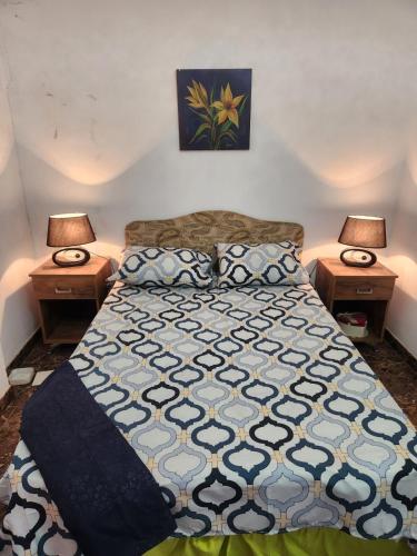 a bedroom with a bed with two lamps on both sides at Beautiful F3 with Sea View in La Reghaia/Boudouaou