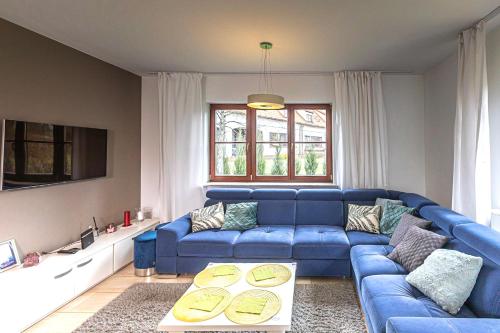 a living room with a blue couch and a table at Willa Basztowa 5 in Pasym