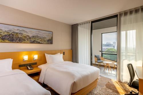 a hotel room with two beds and a balcony at DoubleTree by Hilton Vientiane in Vientiane
