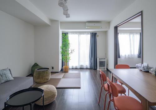 a living room with a couch and a table and chairs at Sun North in Sapporo