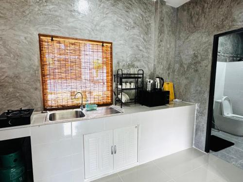 a kitchen with a sink and a window at Bantai Hideaway - House 1 in Baan Tai