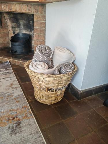 a basket of towels sitting next to a fireplace at Sielerus by Horeb Clarens in Clarens