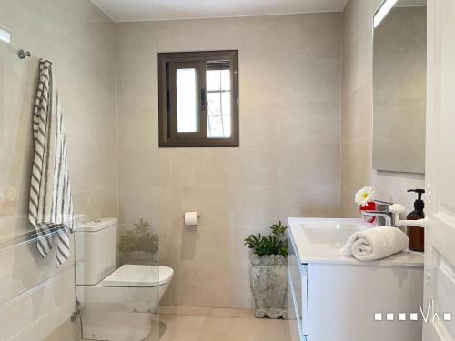 ein Badezimmer mit Toilette und Waschbecken und einem Fenster in der Unterkunft VH CostaBlanca - EL HORIZONTE in Pedramala