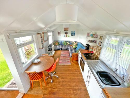 a kitchen and living room in a tiny house at Cool Seaside Hut, Sandy & Quiet Norfolk Beach in Bacton