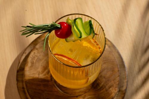 a drink on a glass table with a tomato and cucumbers at Mango Hotels Prangan in Bhubaneshwar