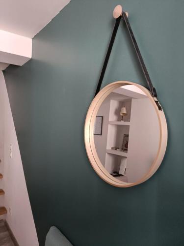 un miroir rond accroché à un mur bleu dans l'établissement Le Triplex Ruthénois, Pet Friendly, HyperCentre, WisdhomeConciergerie, à Rodez