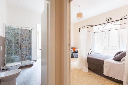 a bedroom with a bed and a bathroom with a sink at G-House Pettinari in Rome