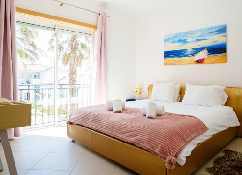 a bedroom with a bed and a large window at The Lazy Sunbathers, Praia del Rei, Óbidos, B11 in Óbidos