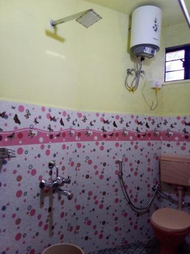 a bathroom with a toilet and a pink wall with hearts at Matti I Pa Homestay in Cherrapunji