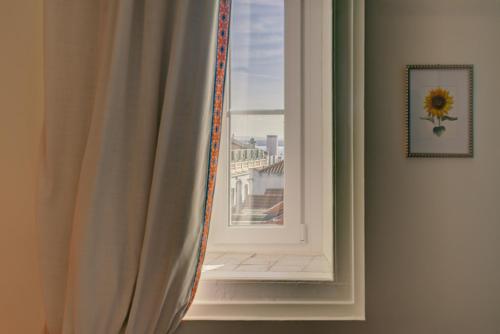 a view of a window with a sunflower at Casinha das Flores in Lisbon