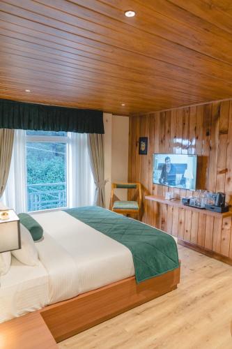 a bedroom with a large bed and a television at Valmere Lungta Boutique Hotel & Spa in Darjeeling