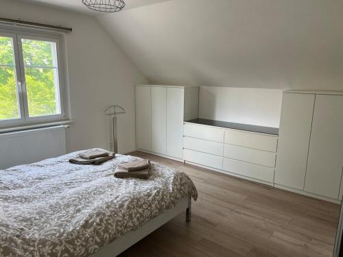 a white bedroom with a bed and a window at TheBeautifulView in Saint-Louis