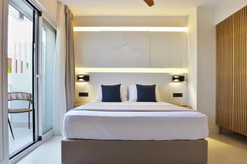a bedroom with a large bed with blue pillows at Palm Boutique Suites in Pefkohori