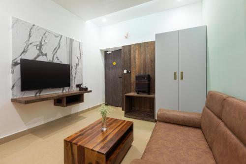 a living room with a couch and a tv at Kaira Park in Chennai